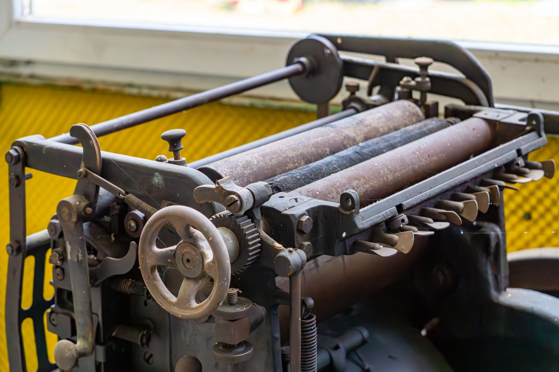 Industrial printing machine with metal rollers — custom apparel printing craftsmanship