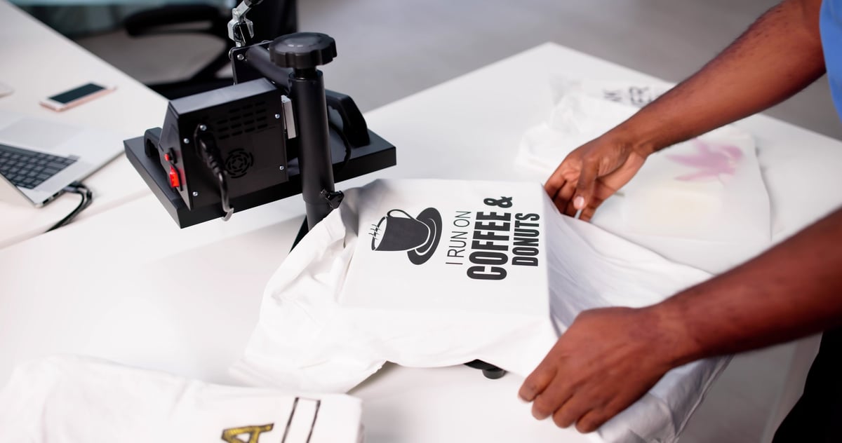 African-American Man Screen Prints Custom Logo T-shirt At Heat Press Factory