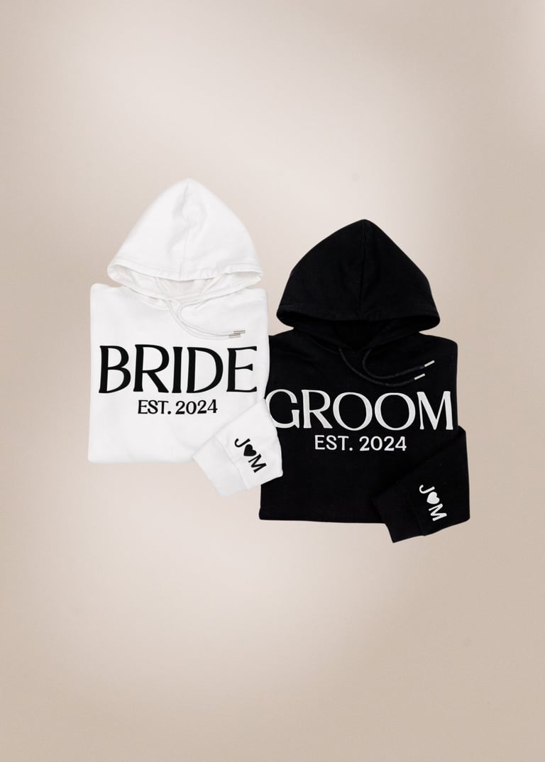 White and black hoodies with BRIDE and GROOM text, EST. 2024, displayed as a matching couple set