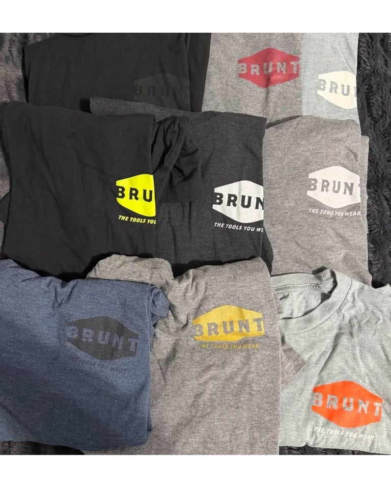 Collection of folded BRUNT brand t-shirts in various colors
