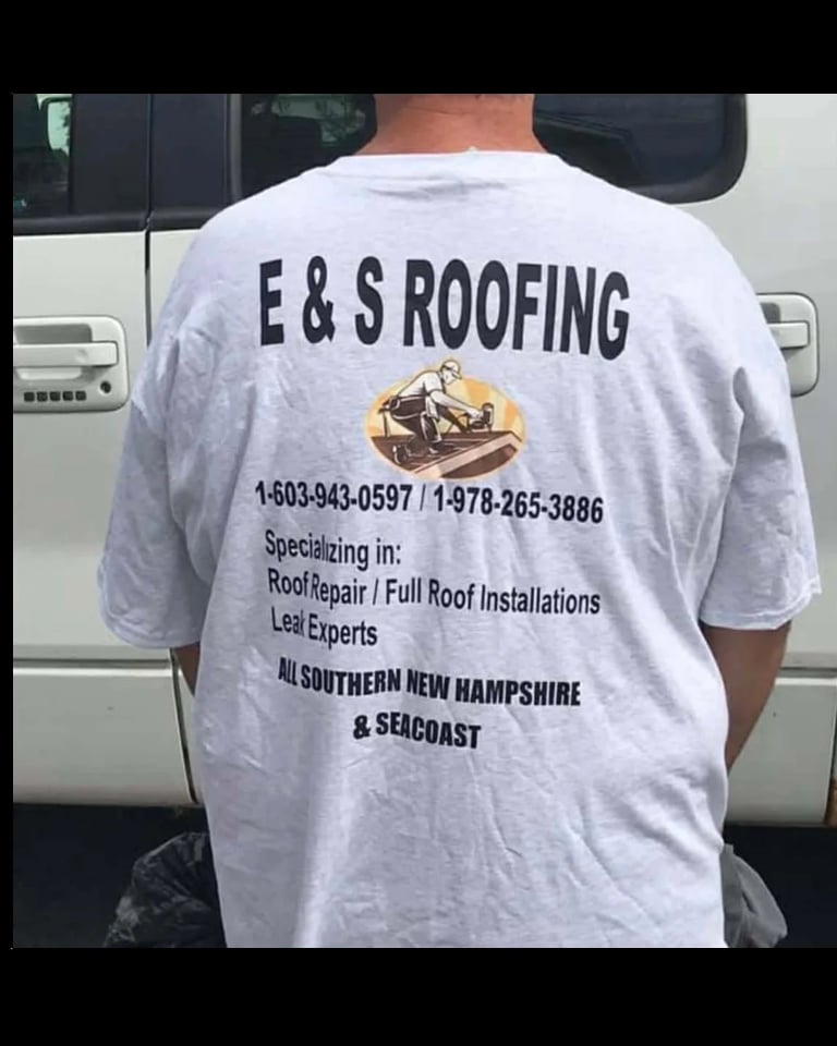 Person wearing gray E & S Roofing company t-shirt with contact numbers and service details printed on back