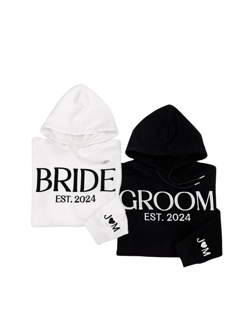 White and black hoodies labeled BRIDE EST. 2024 and GROOM EST. 2024