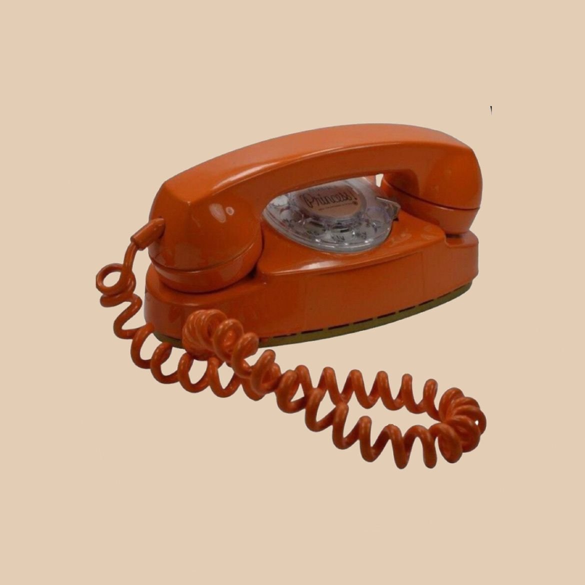 Vintage orange rotary telephone with coiled cord on beige background