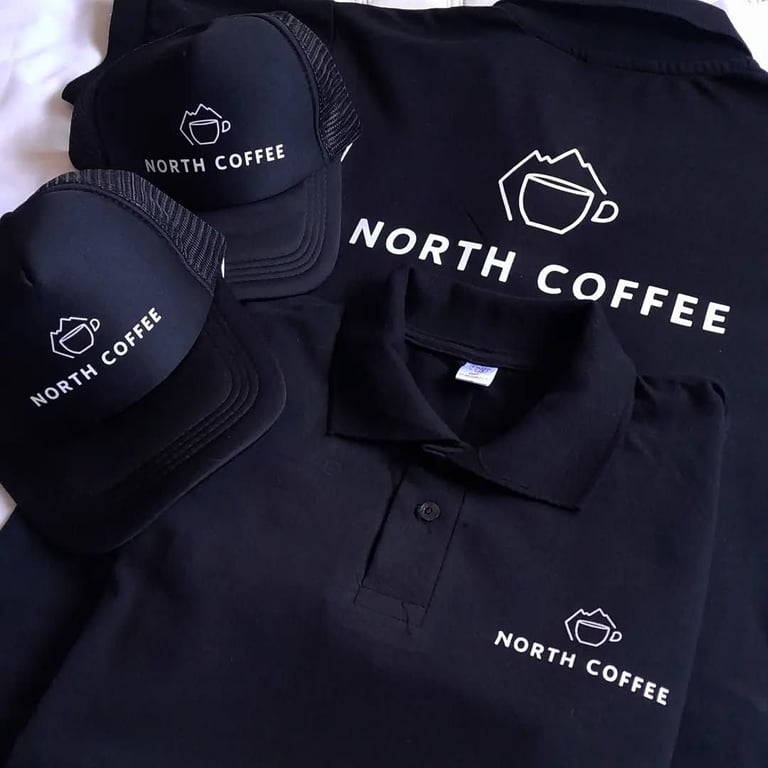 North Coffee branded merchandise collection including black polo shirt and matching trucker caps with coffee cup logo