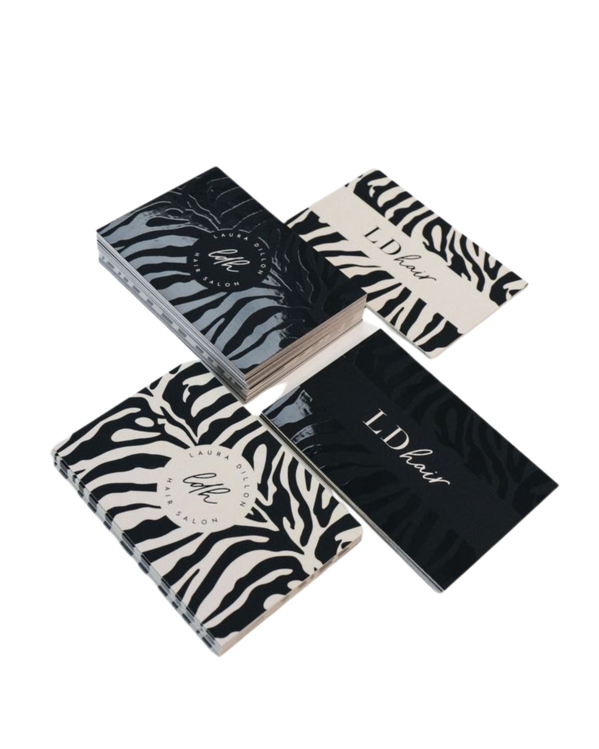 Collection of four luxury beauty and fragrance boxes with zebra stripe and solid black designs arranged in a display