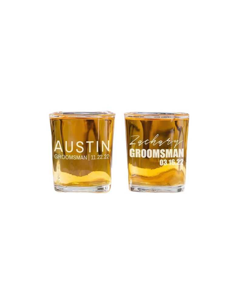 Two engraved whiskey glasses filled with amber liquid