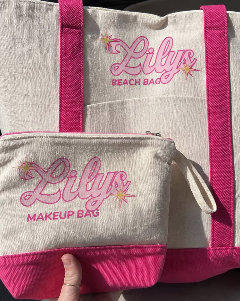 Two beige and pink canvas bags with Lilly branding - a beach bag and makeup bag with embroidered text and star designs