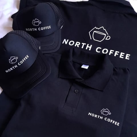 North Coffee branded merchandise including black caps and polo shirt with coffee cup logo