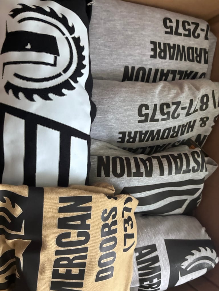 Stack of folded Atlanta Hawks merchandise and apparel with team logos and text visible on the garments