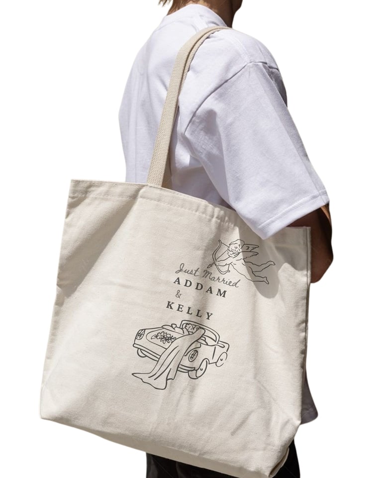 Person carrying beige canvas tote bag with line drawing design